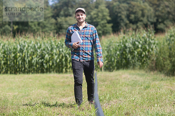 Landwirt auf dem Feld trägt Papierkram