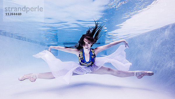 Unterwasseraufnahme eines Teenager-Mädchens in Ballettschuhen  in Tanzposition