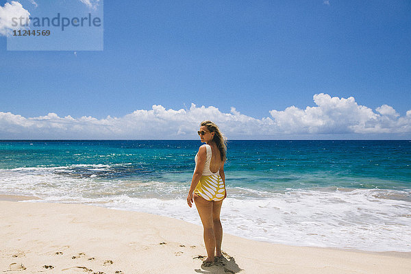 Schwangere Frau mittleren Alters im Badeanzug beim Rückblick vom Strand von Makua  Hawaii  USA