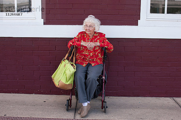 Ältere Frau im Rollstuhl sitzend  im Freien