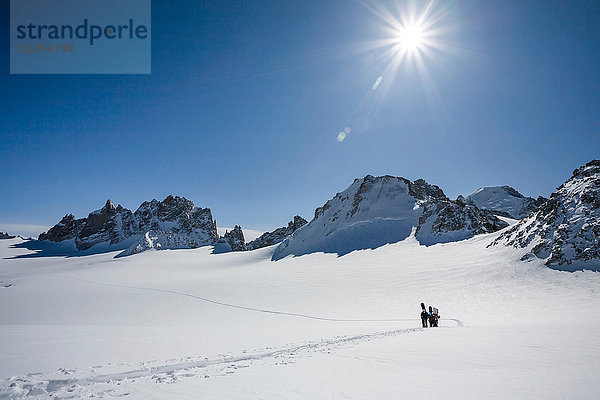 Vier männliche Snowboarder wandern durch verschneite Landschaft  Trient  Schweizer Alpen  Schweiz