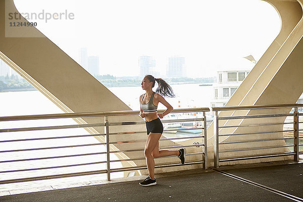 Frau joggt auf erhöhtem Gehsteig  Südbund  Shanghai  China
