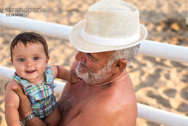 Großvater hält lächelnden kleinen Jungen