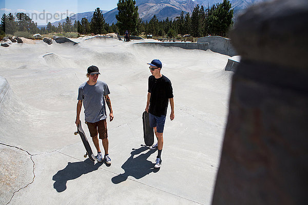 Zwei junge männliche Skateboarder unterhalten sich im Skatepark  Mammoth Lakes  Kalifornien  USA