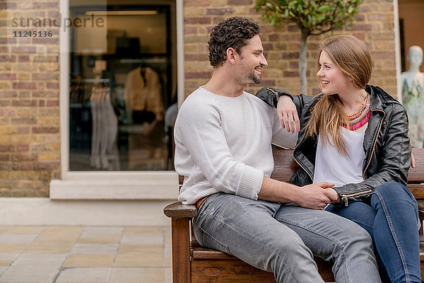 Romantisches junges Paar auf Bank sitzend  Kings Road  London  UK
