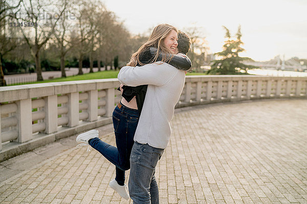 Romantischer junger Mann umarmt Freundin im Battersea Park  London  Großbritannien