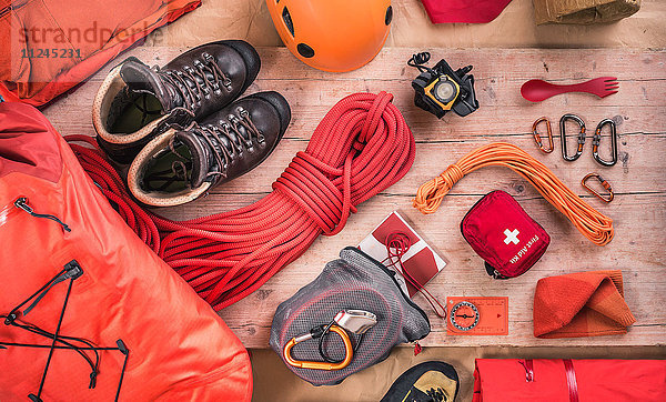 Draufsicht auf die Kletterausrüstung mit Kletterhelm  Erste-Hilfe-Kasten  Kletterschuhen und Kletterseilen