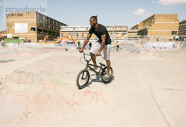 Junger Mann fährt BMX-Fahrrad im Skatepark