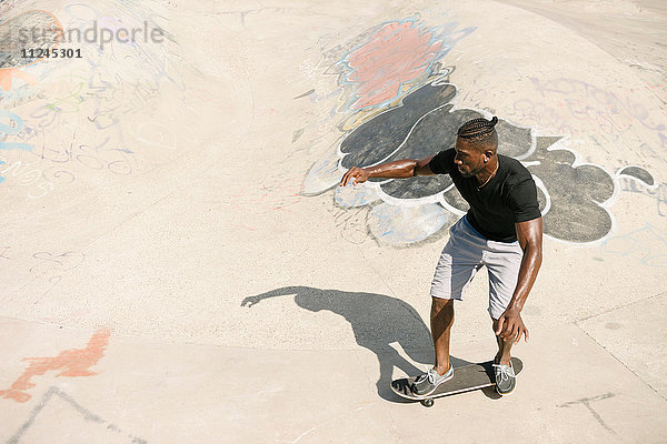 Junge männliche Skateboarder skateboarden im Skatepark