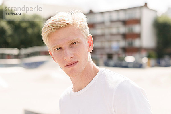 Porträt eines blonden jungen männlichen Skateboardfahrers im Skatepark
