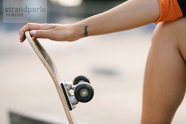 Schnappschuss einer Skateboardfahrerin  die ein Skateboard hält