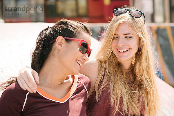 Zwei Skateboard-Freundinnen lachen im Skatepark