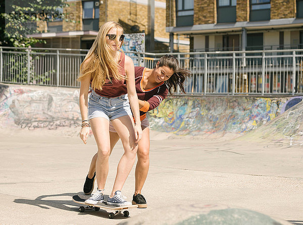 Zwei Frauen üben im Skatepark das Gleichgewicht auf dem Skateboard