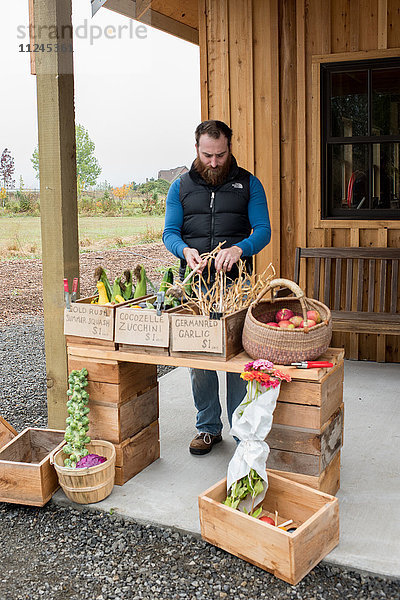 Mittelgroßer erwachsener Mann bereitet Obst und Gemüse im Bioladen