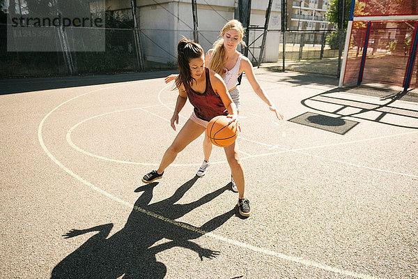 Zwei Basketballerinnen üben auf dem Basketballplatz