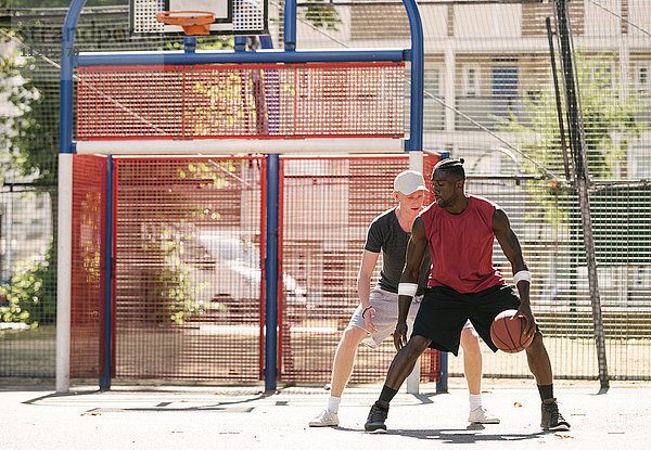 Zwei männliche Basketballspieler üben auf dem Basketballfeld