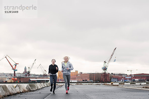 Zwei Freundinnen laufen am Hafen entlang