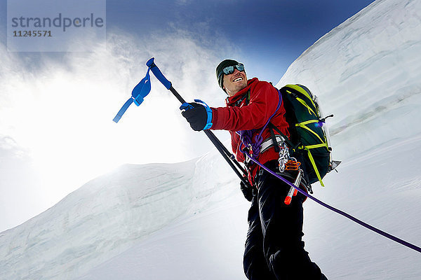 Bergsteiger mit Wanderstöcken in der Hand schauen lächelnd weg  Saas Fee  Schweiz