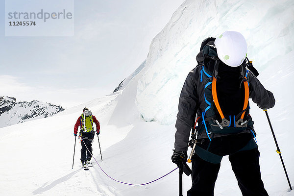 Rückansicht von Bergsteigern beim Skitourengehen auf schneebedecktem Berg  Saas Fee  Schweiz