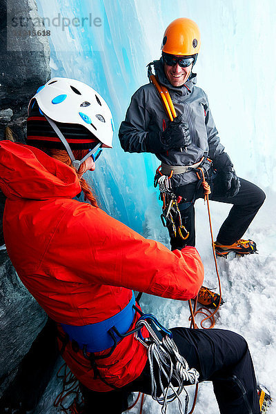 Eiskletterer in Eishöhle bereiten Kletterausrüstung vor