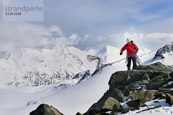 Mann auf der Spitze eines schneebedeckten Bergwurf-Kletterseils  Saas Fee  Schweiz