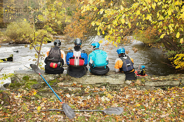 Rückansicht von Kajakfahrern  die von der Uferwand des Flusses blicken  River Dee  Llangollen  Nordwales