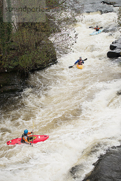 Hochwinkelaufnahme von Kajakfahrern  die in den Wildwasserschnellen des River Dee paddeln  Llangollen  Nordwales