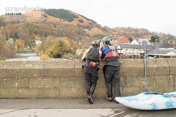 Rückansicht von zwei Kajakfahrern  die von der Brücke auf dem River Dee hinausblicken  Llangollen  Nordwales