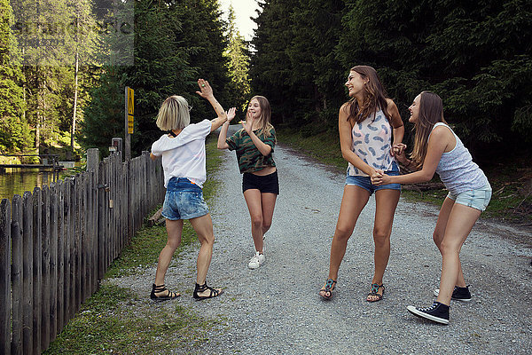 Mädchen und erwachsene Freundinnen auf Waldweg
