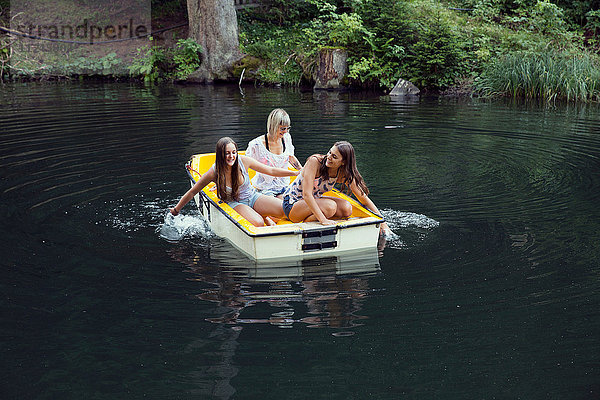 Drei erwachsene Freundinnen paddeln Ruderboot auf dem See  Sattelbergalm  Tirol  Österreich