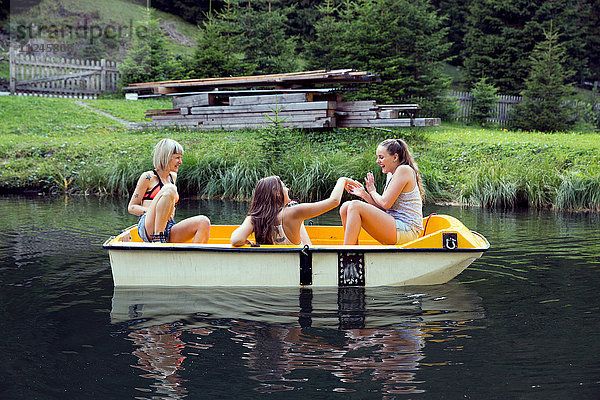 Drei erwachsene Freundinnen amüsieren sich im Ruderboot auf dem See  Sattelbergalm  Tirol  Österreich