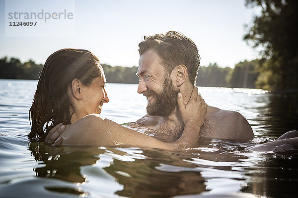 Lächelndes Paar von Angesicht zu Angesicht umarmend im Wasser  Berlin  Deutschland