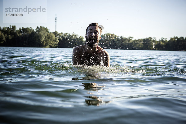 Mann mit offenem Mund  spritzend im Wasser  Berlin  Deutschland
