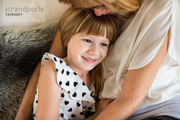 Mutter und Tochter kuscheln im Bett