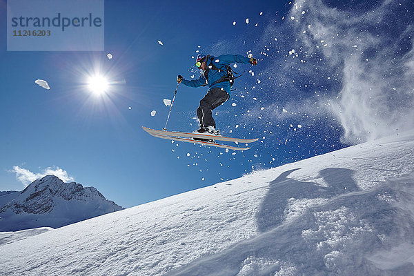 Männlicher Freestyle-Skifahrer springt in der Luft von einem Berghang  Zugspitze  Bayern  Deutschland