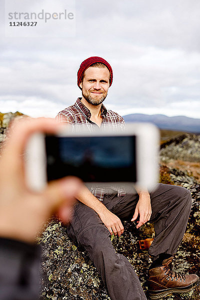 Wanderer beim Fotografieren auf dem Klippengipfel  Keimiotunturi  Lappland  Finnland