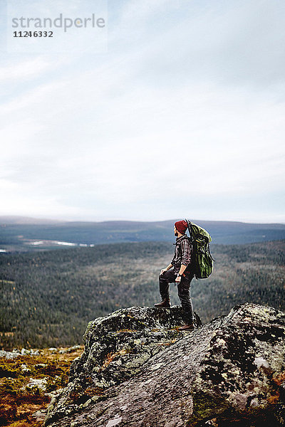 Wanderer geniesst Aussicht auf die Klippen  Keimiotunturi  Lappland  Finnland