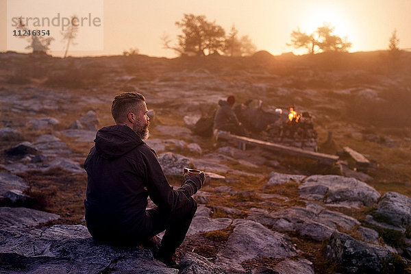 Wanderer entspannt bei Kaffee auf felsigem Feld  Sarkitunturi  Lappland  Finnland