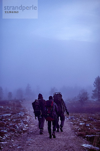 Wanderer durchqueren felsiges Feld in der Dämmerung  Sarkitunturi  Lappland  Finnland