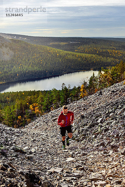 Wanderer  der einen steilen Hügel hinaufläuft  Kesankitunturi  Lappland  Finnland