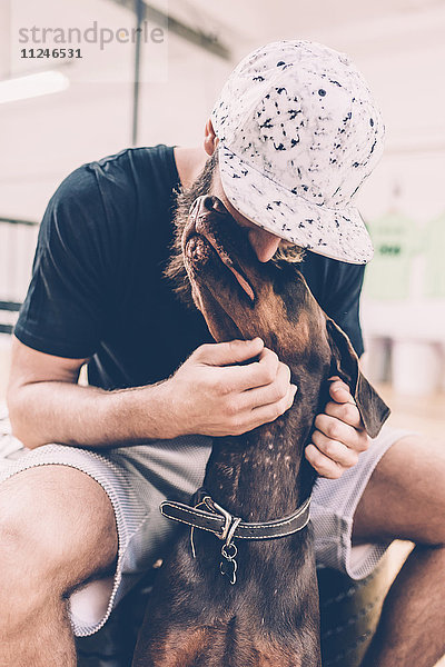 Junger männlicher Hipster-Streichelhund