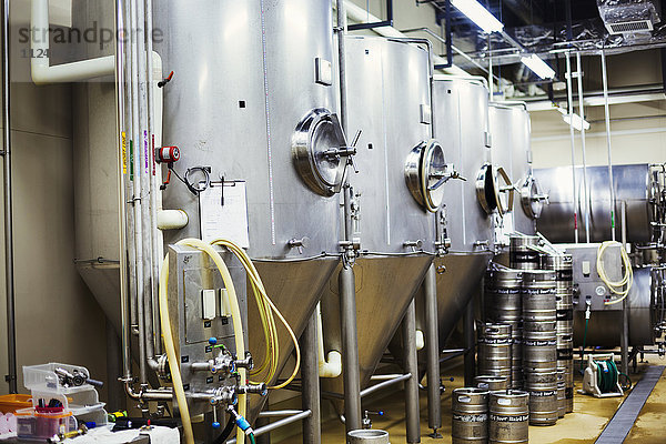Reihe von großen Metallbiertanks in einer Brauerei.