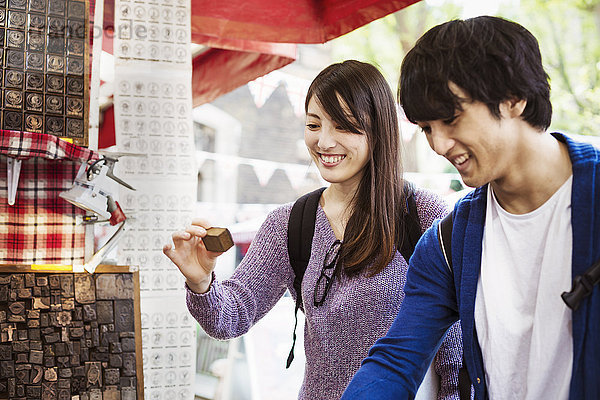 Zwei japanische Touristen beim Einkaufen an einem Straßenstand.