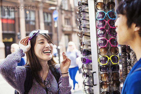 Eine Japanerin  die in London eine Sonnenbrille anprobiert  eine Sommertouristin.