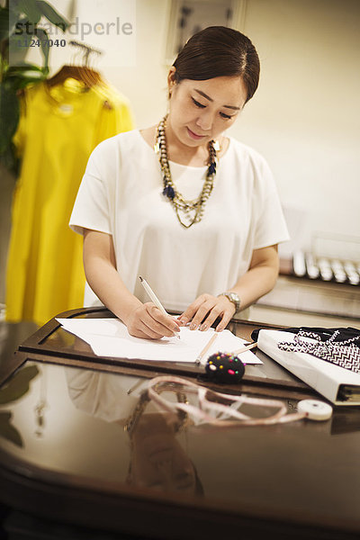 Frau  die in einer Modeboutique in Tokio  Japan  arbeitet und schreibt.