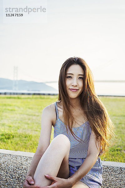 Bildnis einer lächelnden jungen Frau mit langen braunen Haaren.