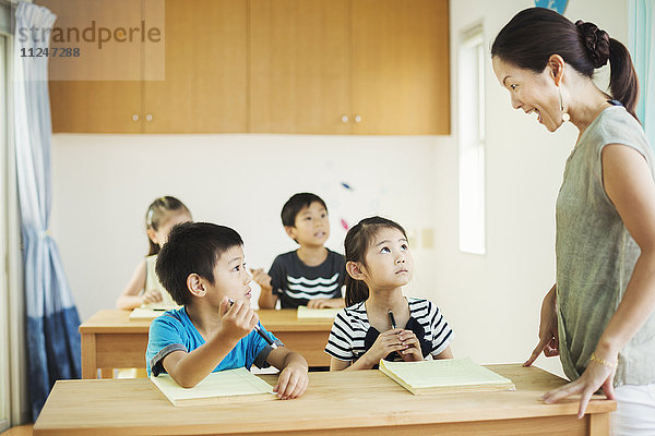 Eine Gruppe von Kindern in einem Klassenzimmer mit ihrer Lehrerin.