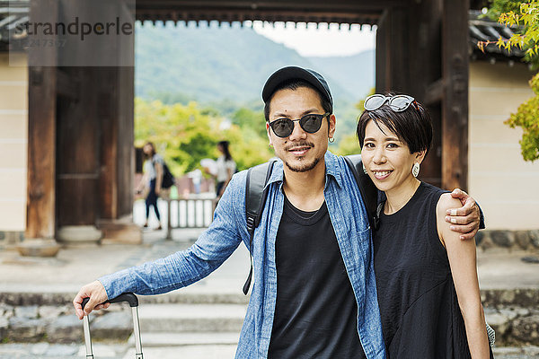 Ein Mann und eine Frau besuchen einen historischen Tempel in Japan.