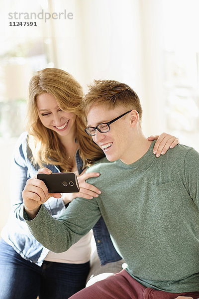 Junges Paar sieht sich einen Film auf dem Smartphone an