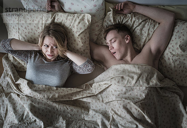 Junges Paar im Bett  Mann schnarcht